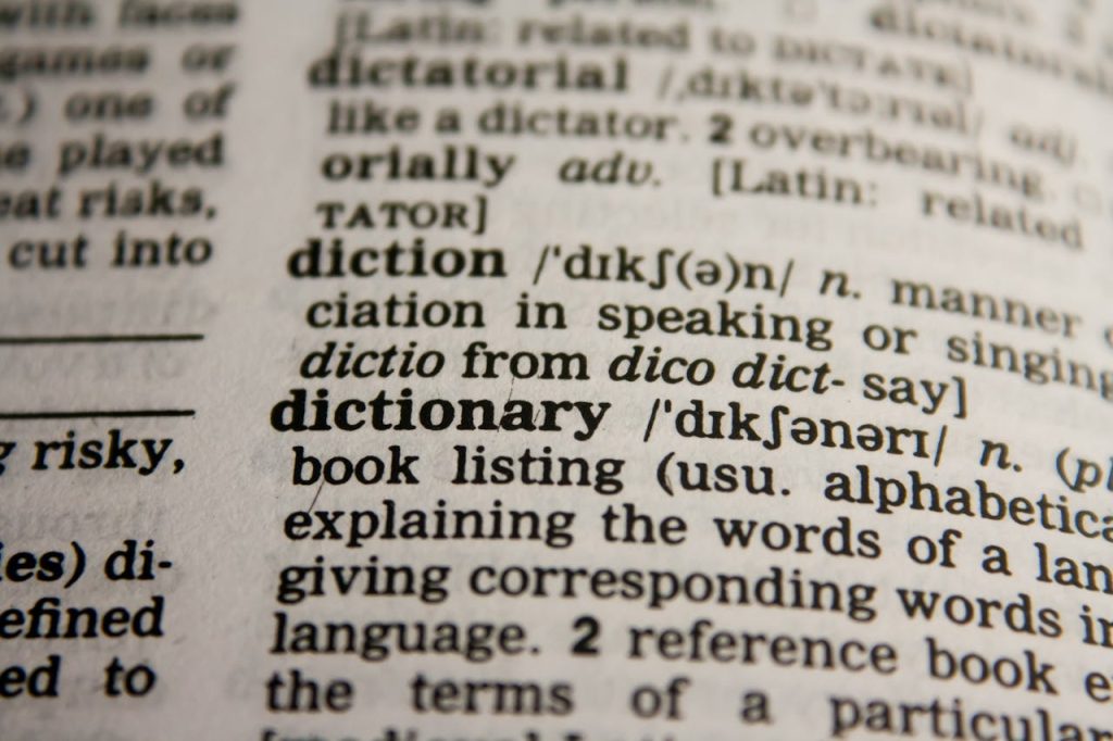 Detailed close-up view of a dictionary page highlighting the word dictionary and its definition.